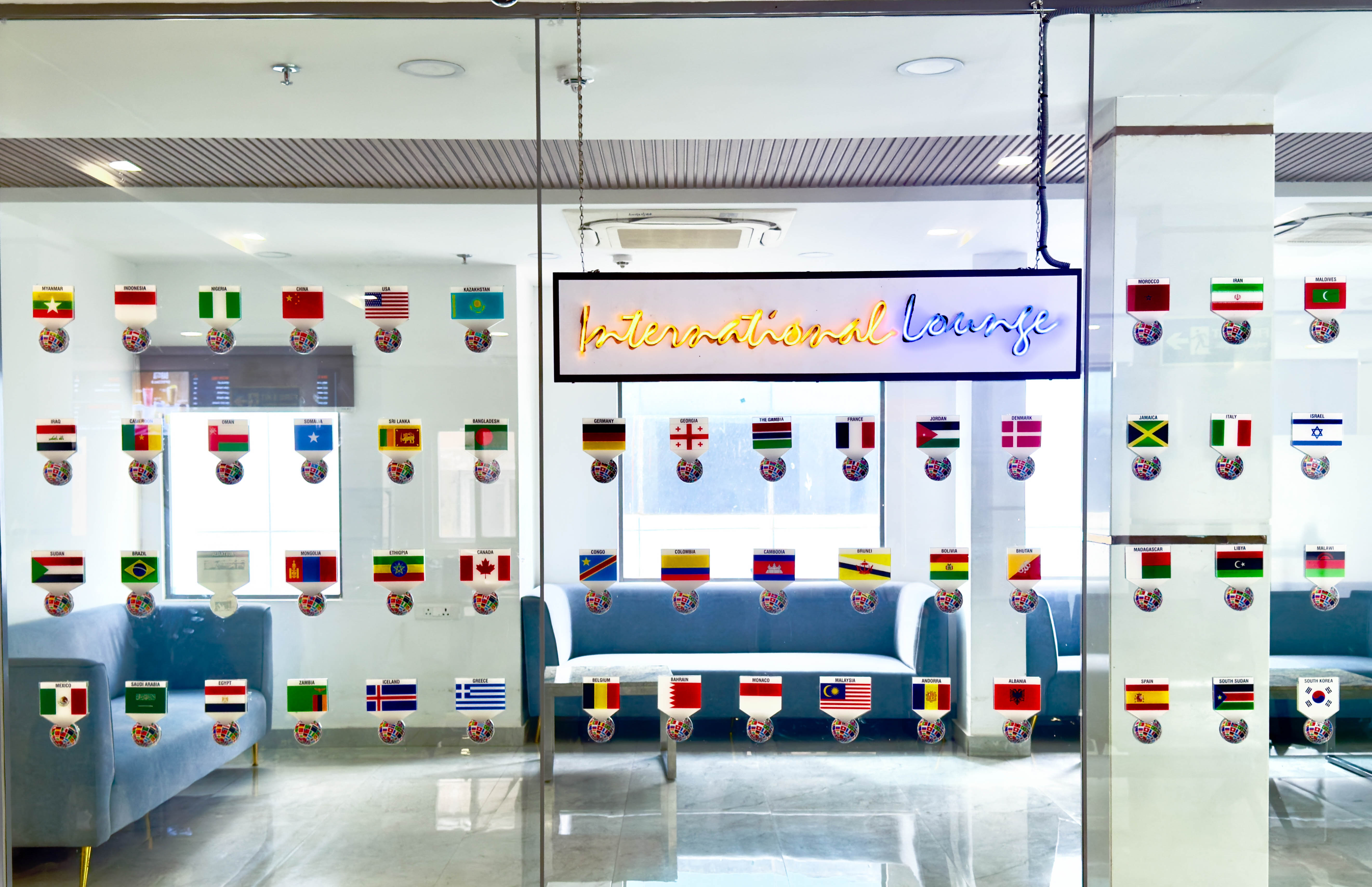 An international patient lounge at a Hyderabad hospital, with seating and flags marking the many countries served